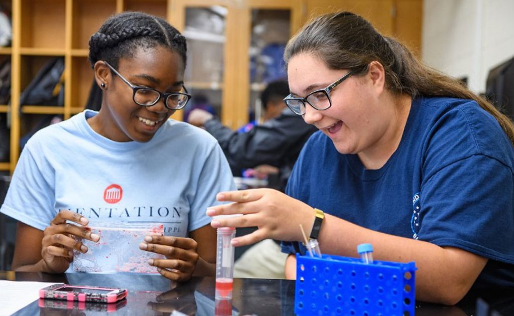 Biology lab partners Chinwe Udemgba and Ashley Adams screen a mixture of strawberry and detergent into a tube to extract the strawberry DNA.